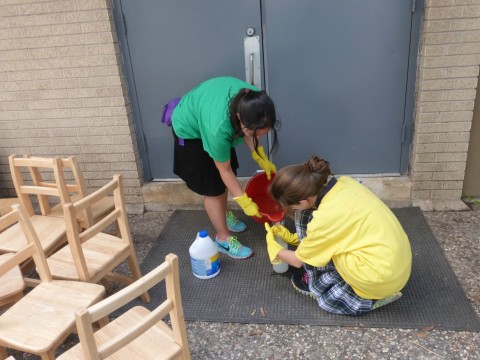 Student Ariella Levie, left, and a middle school student from the Robert M. Beren Academy get ready to disinfect all of the chairs from the Goldberg Montessori School housed in United Orthodox Synagogues, which was destroyed.