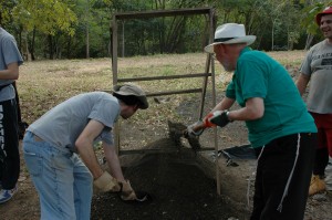 Student and Rabbi Blau, right, shovel dirt to be used in mixing cement for village library.
