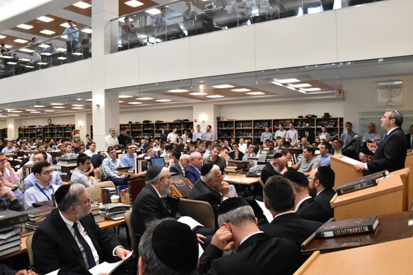 Rabbi Dr. Ari Berman speaks to a large crowd in the Beit Midrash.