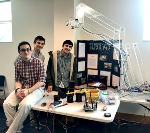 (l-r): YUHSB’s Hanan Berger, Benny Jacob and GJ Neiman with the robotic arm they built together.